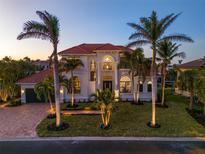 Stunning two-story home with a tile roof and palm trees at 531 Ranger Ln, Longboat Key, FL 34228