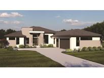 Modern single-story home with a two-car garage and landscaped lawn at 4129 Butte Trl, Lakewood Ranch, FL 34211