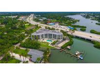 Aerial view of waterfront condo building with pool and boat slips at 516 Tamiami S Trl # 102, Nokomis, FL 34275