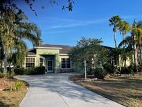 Charming single-story home featuring a well-manicured lawn, a long driveway, and lush tropical landscaping at 2910 122Nd E Ter, Parrish, FL 34219