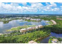 Aerial view of a lakefront community with lush landscaping and modern buildings at 6438 Watercrest Way # 204, Lakewood Ranch, FL 34202