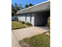 Light gray condo building with a gray roof and small front yard at 4160 Fruitville Rd # 13, Sarasota, FL 34232
