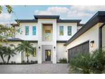 Modern two-story home with white facade, dark gray roof, and a welcoming front entrance at 2420 Floyd St, Sarasota, FL 34239