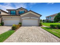 Two-car garage, paver driveway, and landscaped front yard at 5830 Wake Forest Run # 104, Bradenton, FL 34211