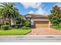 Single-story home with tile roof, landscaping, and brick driveway at 7112 Marsh View Ter, Bradenton, FL 34212