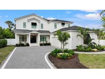 Stunning two-story home featuring a manicured lawn, beautiful landscaping, and a stylish black and white color scheme at 1783 Bayview Dr, Sarasota, FL 34239