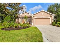 Charming single-story home with a well-manicured lawn, beautiful landscaping, and a two-car garage at 105 New Briton Ct, Bradenton, FL 34212