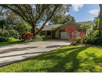 Charming single-story home boasts mature trees, lush landscaping, and a two-car garage with a concrete driveway at 1741 Jewel Dr, Sarasota, FL 34240