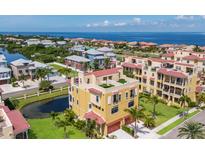 Stunning aerial view of a beautiful home with green roof, a pond, and community near the ocean at 1450 Silvia Shores Dr, Apollo Beach, FL 33572