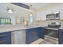 Modern kitchen with stainless steel appliances and blue cabinetry at 26336 Nadir Rd # 12, Punta Gorda, FL 33983