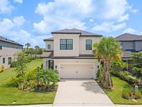 Two-story house with beige exterior, landscaping, and a two-car garage at 8370 Velda Trl, Sarasota, FL 34241