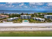 Aerial view of beachfront condo community with pool and lush landscaping at 4825 Gulf Of Mexico Dr # 105, Longboat Key, FL 34228