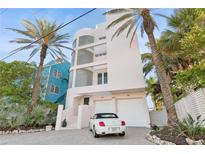 Three-story house with white walls, glass block accents, and a two-car garage at 648 Beach Rd, Sarasota, FL 34242