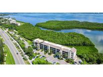 Aerial view of a condo building near the water with lush landscaping at 4540 Gulf Of Mexico Dr # Ph1, Longboat Key, FL 34228