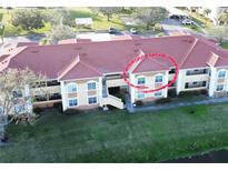 Aerial view of condo building with red tile roofs and landscaping at 1050 Villagio Cir # 206, Sarasota, FL 34237