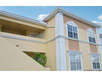 Tan building exterior with white columns and arched windows at 1050 Villagio Cir # 206, Sarasota, FL 34237