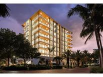 Luxury condo building at night, featuring modern architecture and landscaped grounds at 111 Golden Gate Pt # 201, Sarasota, FL 34236