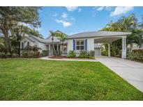 Single-story home with a covered porch, lush lawn, and mature landscaping at 4532 Shark Dr, Bradenton, FL 34208