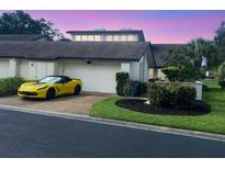 Updated condo with attached garage and a yellow sports car parked in the driveway at 4646 La Jolla Dr # 9A, Bradenton, FL 34210