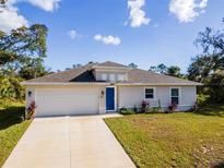 Newly constructed home with a neutral color palette and a two-car garage at 1702 Rada Ln, North Port, FL 34288