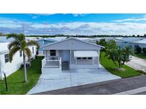 Charming single-story home featuring a cozy porch, palm trees, and a well-maintained lawn at 3333 26Th E Ave # 1230, Bradenton, FL 34208