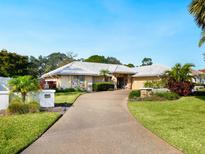 Beautiful home with a large driveway and lush landscaping at 5050 Kestral Park S Way, Sarasota, FL 34231