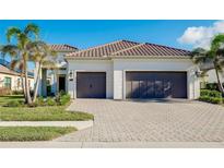 White two-story house with brown roof, two-car garage, and landscaped yard at 284 Corelli Dr, Nokomis, FL 34275