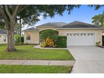 Charming single-story home featuring a well-manicured lawn, mature trees, and an attached two-car garage at 4938 72Nd E Ct, Bradenton, FL 34203