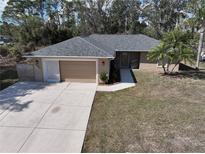 Charming single-story home with attached garage, driveway, and mature landscaping at 4337 Mermell Cir, North Port, FL 34291