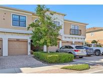 Tan townhome exterior with two-car garage and manicured landscaping at 4157 Overture Cir # 383, Bradenton, FL 34209