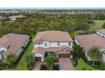 Luxury home with tile roof, two-car garage, and lush landscaping at 13107 Belknap Pl, Lakewood Ranch, FL 34211