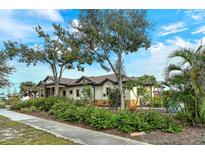 Single-story home with tile roof, landscaped yard, and stone accents at 1109 The Rialto, Venice, FL 34285