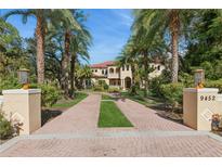 Grand two-story home with palm trees and brick driveway at 9452 Swaying Branch Rd, Sarasota, FL 34241