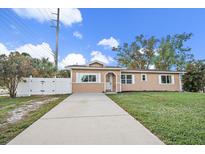 Tan house with white shutters, driveway, and landscaped lawn at 15 Tulane Rd, Venice, FL 34293