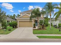 Two-story house with a tan exterior, two-car garage, and landscaping at 12224 Longview Lake Cir, Bradenton, FL 34211