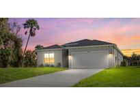 Two-story house with a light gray exterior and a landscaped yard at 1800 S San Mateo Dr, North Port, FL 34288