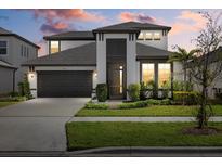 Two-story house with a dark gray roof, white walls, and a dark brown front door at 3512 Hidden Creek Blvd, Sarasota, FL 34240