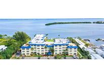 Aerial view of waterfront condo building with parking and boat slips at 3808 Gulf Of Mexico Dr # E307, Longboat Key, FL 34228