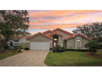 Tan house with orange roof, white garage door, and landscaped lawn at 5296 White Sand Ne Cir, St Petersburg, FL 33703