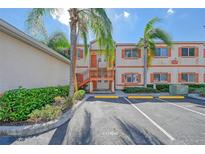 Exterior view of condo building with parking and landscaping at 3956 Mediterranea Cir # 412, Sarasota, FL 34233