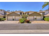 Three-unit condominium building with attached garages and lush landscaping at 1676 Starling Dr # 202, Sarasota, FL 34231