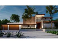 Modern home with wood and white accents, two-car garage, and palm trees at 109 N Warbler Ln, Sarasota, FL 34236