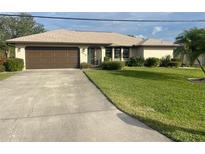 Single story home with brown garage door and well-maintained lawn at 1478 Navigator Rd, Punta Gorda, FL 33983