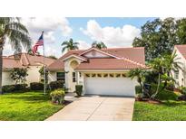 One-story home with tile roof, two-car garage, and landscaped lawn at 4872 Limetree Ln, Venice, FL 34293