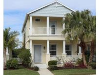 Two-story house with light yellow siding, gray accents, and a front porch at 4707 Woodbrook Dr, Sarasota, FL 34243