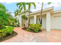 Bright, inviting exterior with a paved walkway, lush landscaping, and palm trees at 1954 Datura St, Sarasota, FL 34239
