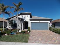 One-story home with stone accents, gray garage door, and landscaped yard at 13005 Rinella St, Venice, FL 34293