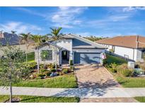 Single-story home with stone accents, landscaped yard, and a two-car garage at 13005 Rinella St, Venice, FL 34293