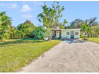 Light green house with a spacious lawn and driveway at 2910 49Th St, Sarasota, FL 34234