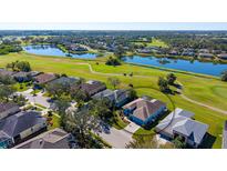 Aerial view of home on golf course with pool and pond views at 10643 Old Grove Cir, Bradenton, FL 34212